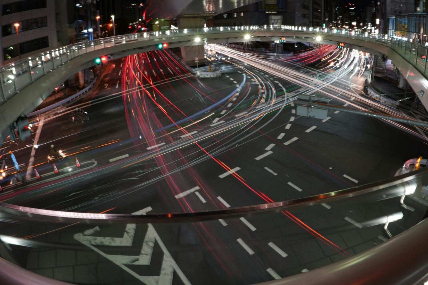 Nighttime view of intersecting roads with light trails, symbolizing Executive MBA career change and navigating complex career paths.
