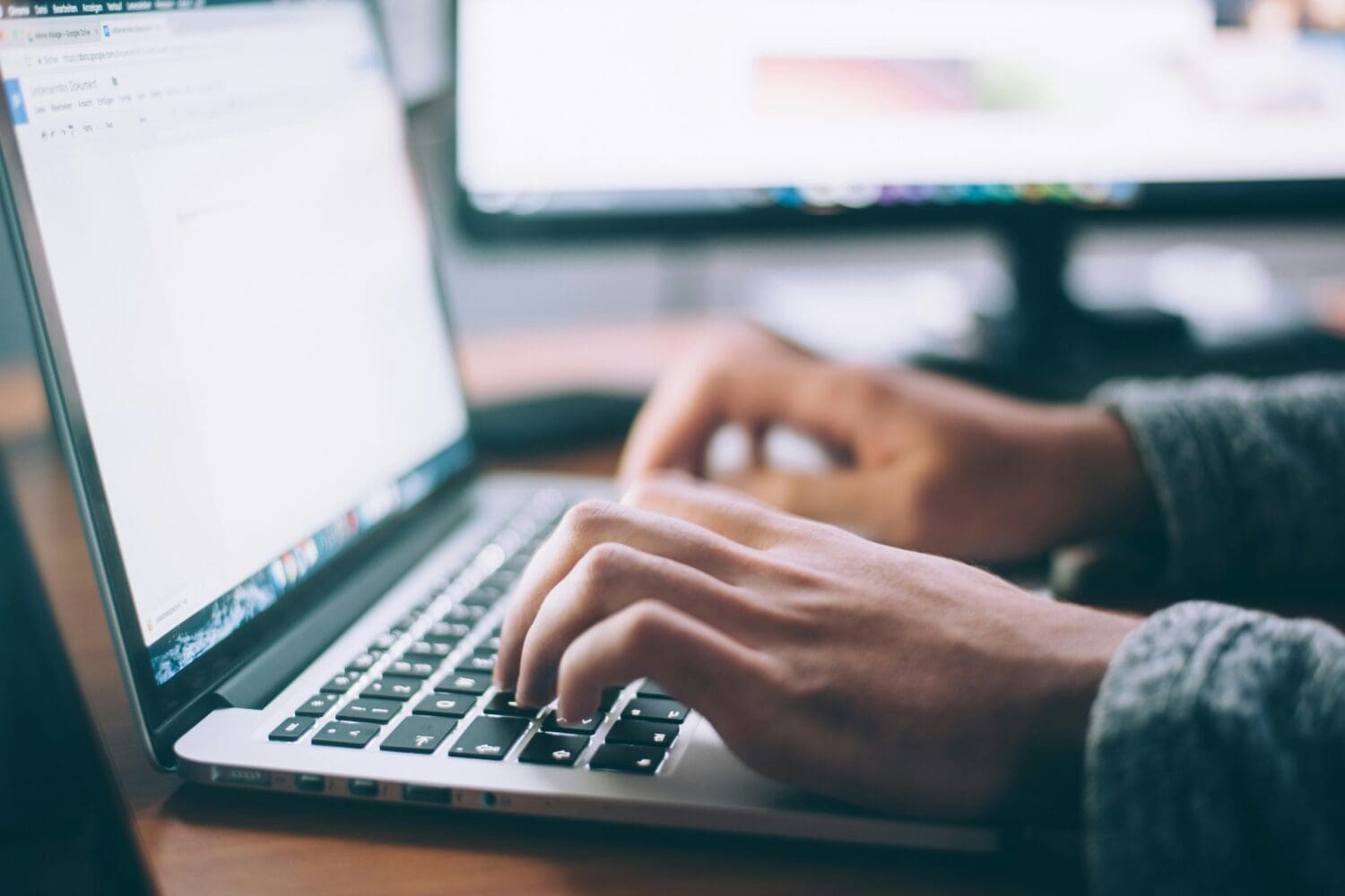 Applicant writing MBA resume bullet points on laptop for business school application.