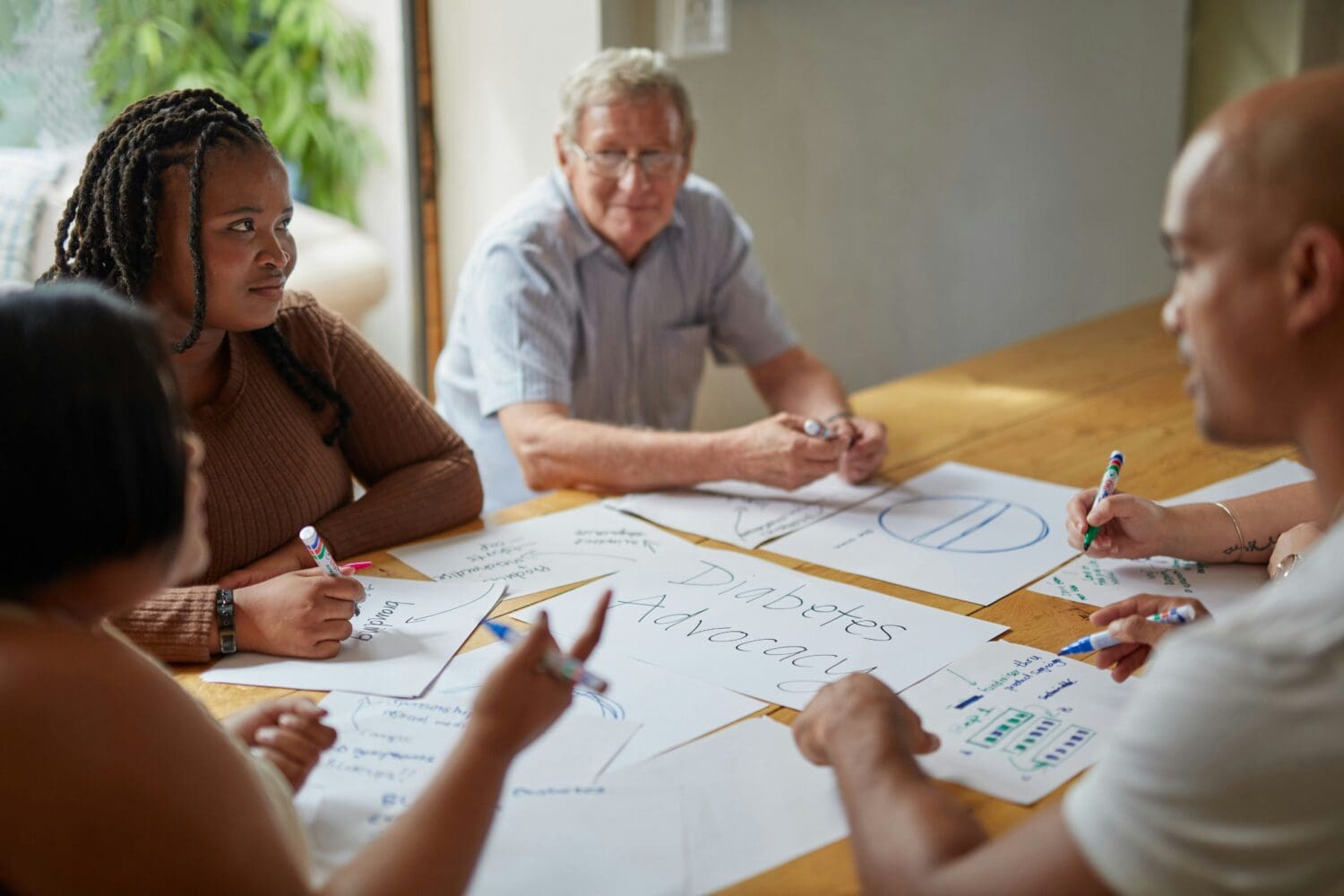 Diverse volunteers planning around a table with advocacy documents, representing the career and networking benefits of skills-based volunteering.